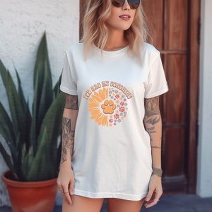 May include: White t-shirt with a sunflower design and the text "You are my sunshine" with paw prints in the center of the sunflower.