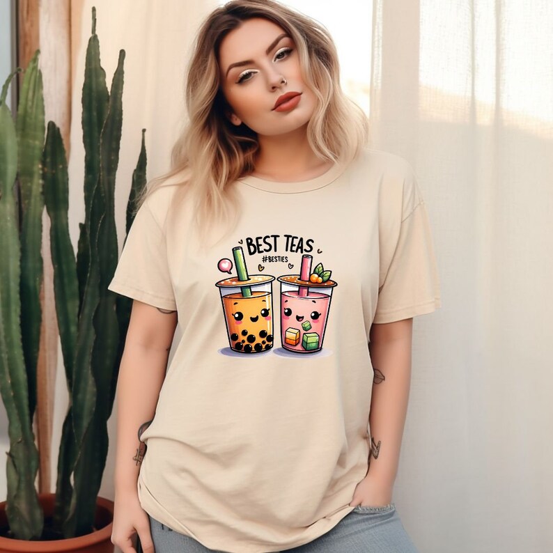 May include: A beige t-shirt with a graphic of two cartoon bubble tea cups with faces. The text "Best Teas" is above the cups and "#Besties" is below the cups.
