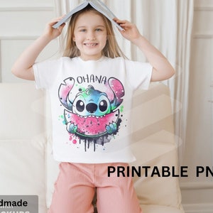 以下が含まれることがあります： リロ＆スティッチのスティッチがスイカを食べているカラフルな漫画の画像がプリントされた白いTシャツ。画像の上に「オハナ」という文字がプリントされています。シャツは子供によってモデル化されています。