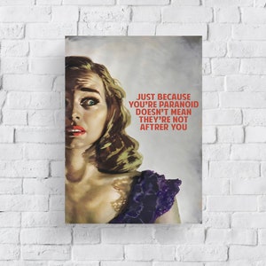 May include: A vintage-style poster with a woman looking over her shoulder with a worried expression. The text on the poster reads "Just because you're paranoid doesn't mean they're not after you."