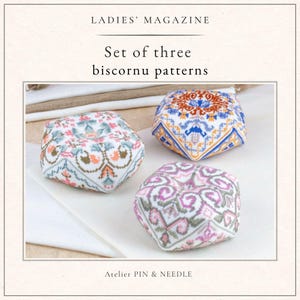 May include: Set of three biscornu patterns. The image shows three colorful, geometric biscornu pincushions. The pincushions feature intricate cross-stitch designs in shades of pink, blue, orange, and green. The text "LADIES' MAGAZINE" and "Atelier PIN & NEEDLE" are also visible.