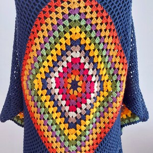 May include: A navy blue crochet top with a colorful diamond-shaped granny square design in the center.