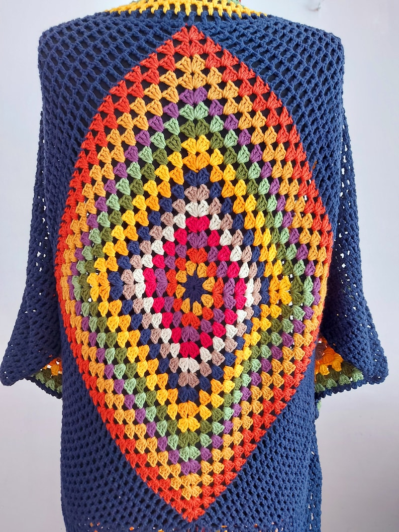 May include: A navy blue crochet top with a colorful diamond-shaped granny square design in the center.