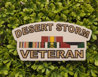 May include: A white sticker with the text "Desert Storm Veteran" in gold lettering. The sticker features a row of military ribbons, including the Saudi Arabian Liberation Medal.