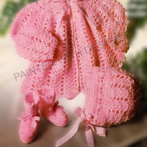 May include: A light pink crochet baby set, comprising a jacket, bonnet, and booties. The set features delicate openwork and is adorned with satin ribbons. The jacket has a scalloped edge, and the booties have bows. A charming, soft baby clothing set.