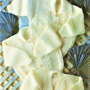 以下が含まれることがあります： ボタン留めとケーブル編みのディテールが施された、白いニットカーディガン3枚