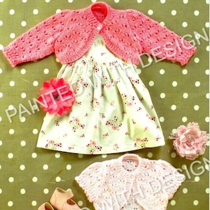 Peut inclure: Deux gilets en tricot rose pour bébé avec un motif ajouré délicat. Le gilet de gauche est d'une nuance de rose légèrement plus foncée que le gilet de droite.