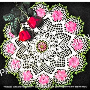 May include: White crochet doily with a green border and pink flower accents. The doily is on a black background with roses.