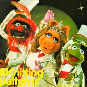 May include: A colorful illustration featuring three Muppet characters: Animal with red fur, Miss Piggy with blonde hair and a tiara, and Kermit the Frog. They wear white tuxedo jackets with red accents and top hats. Yellow text reads 8K Knitting patterns.