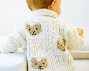 May include: A cream-colored knit cardigan featuring a textured cable knit pattern and three distinct beige bear face motifs on the back. The garment has a collared neckline, long sleeves, and a ribbed hem, worn over a plain light-colored skirt.