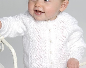 May include: A white long-sleeved knit cardigan featuring a delicate diamond-shaped openwork pattern, vertical cable knit detailing, and a front button closure with small round pearl-like buttons. The garment has a round neckline and ribbed cuffs.