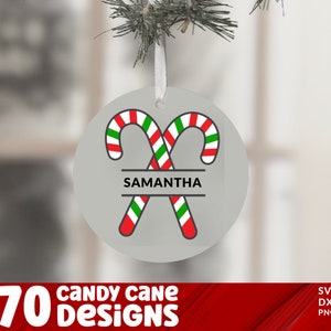 May include: A white round Christmas ornament with two red and white candy canes crossed over each other. The candy canes have green stripes. The ornament has the name "SAMANTHA" written in black letters on a white banner.