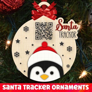 May include: A wooden Christmas bauble featuring a penguin design and a QR code. The bauble is decorated with snowflakes and stars. The text "Santa Tracker" is written on the bauble.