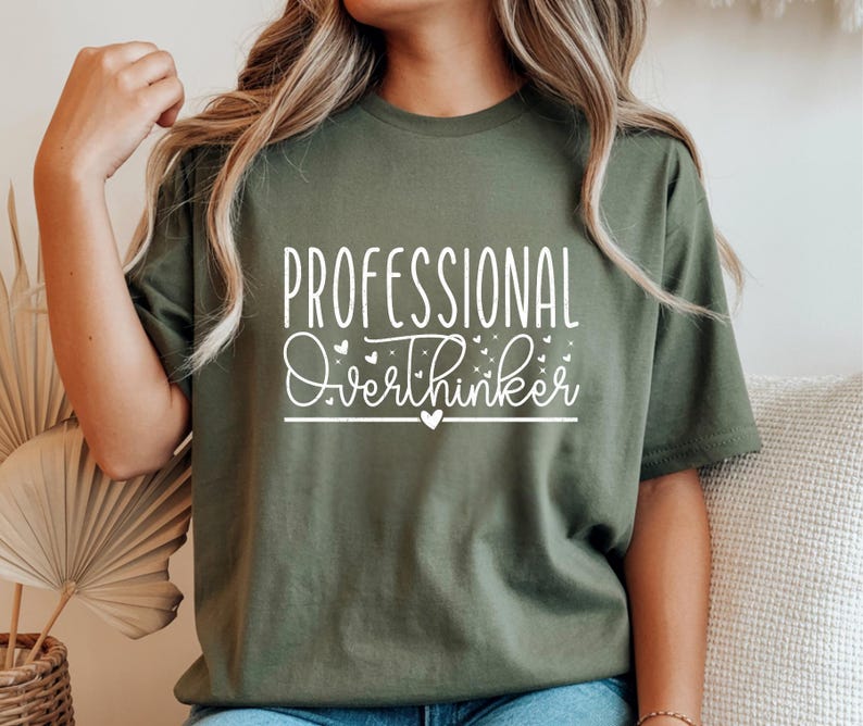 A woman wearing a green t-shirt with the text "Professional Overthinker" printed on it.