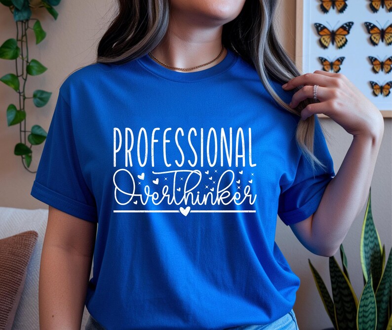 A woman wearing a blue t-shirt with the text "Professional Overthinker" printed on it.