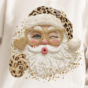May include: White sweatshirt featuring a whimsical Santa Claus design. Santa is depicted with a winking eye, gold-rimmed glasses, and a leopard print hat and mitten. The design includes gold accents and the text "PNG Digital download".