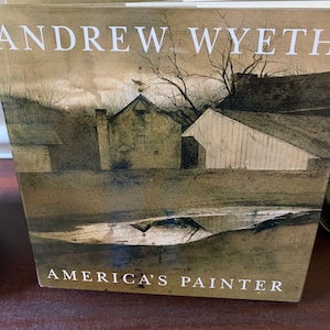 May include: A book cover featuring a painting of a rural landscape with a farmhouse and a small pond. The title of the book is "Andrew Wyeth, America's Painter".