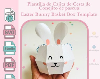 May include: A printable template for a bunny-shaped Easter basket. The template is white with pink ears and a blue ribbon. The text "Plantilla de Cajita de Cesta de Conejito de pascua" and "Easter Bunny Basket Box Template" is included in the image.