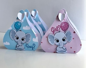 May include: Two gender reveal party favour boxes with elephant designs. The blue box says "Boy?" and the pink box says "Girl?"