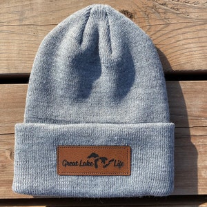 May include: Gray knit beanie with a brown leather patch that says "Great Lake Life" and a silhouette of the Great Lakes.