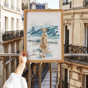 May include: A watercolor painting of a golden retriever dog sitting on a beach, looking out at the ocean waves. The dog is wearing a blue collar and the waves are crashing in the background.