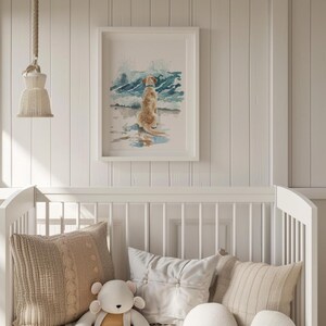 May include: A white framed watercolor painting of a golden retriever dog sitting on a beach with blue waves crashing behind it.