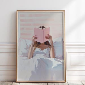 以下が含まれることがあります： ベッドでピンクの本を読んでいる人の絵。その人は白いタンクトップを着て、白いシーツの白いベッドに横たわっています。背景は薄いピンク色です。