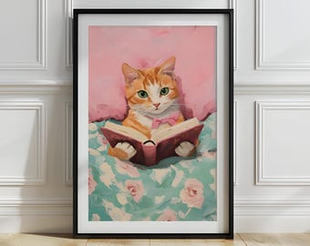 May include: A framed art print featuring a ginger cat with green eyes and a pink bow tie, engrossed in a book. The cat is set against a pink pillow and a floral blanket. The print is in a black frame.