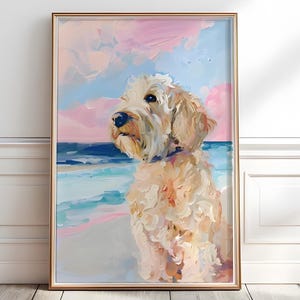 May include: A framed painting of a dog on a beach. The artwork features a fluffy, light-colored dog with a blue collar, set against a backdrop of a pink and blue sky and ocean. The painting has a textured, impressionistic style.