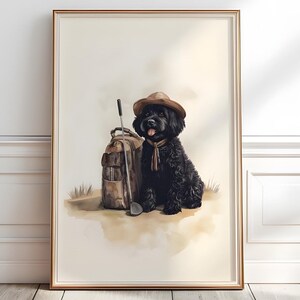 Op de afbeelding: Een ingelijste print met een zwarte hond met een bruine hoed en sjaal, naast een golftas en club. Het kunstwerk is in aquarel stijl met een neutraal kleurenpalet, wat een vintage uitstraling geeft.