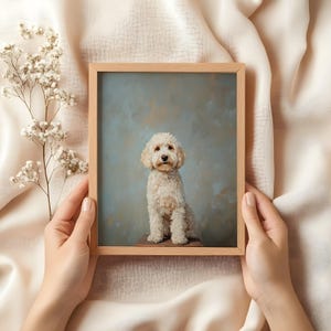 May include: A framed painting of a white dog sitting on a wooden stool. The dog is looking directly at the viewer. The background is a light blue color.