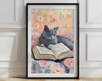 May include: A framed art print showing a grey cat reading a book. The cat is resting on a floral cushion. The background has a soft floral design in pink and peach tones. The artwork is presented in a black frame.