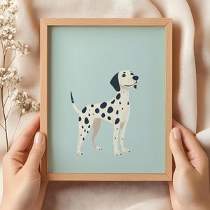 K&ouml;nnte beinhalten: Eine gerahmte Illustration eines Dalmatiners, der auf einem hellblauen Hintergrund steht. Der Hund ist wei&szlig; mit schwarzen Flecken und hat eine schwarze Nase und schwarze Ohren.