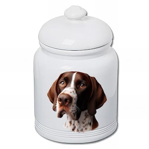 May include: White ceramic storage jar with a lid, decorated with a detailed illustration of a German Shorthaired Pointer. The dog has brown and white markings. The jar has a glossy finish and is suitable for kitchen storage.