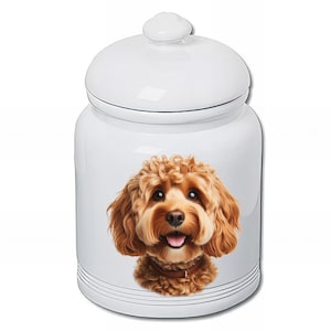 Peut inclure: Pot à friandises pour animaux de compagnie en céramique blanche avec couvercle. Le pot présente une illustration détaillée d'un chien souriant aux cheveux bruns. Le pot est de forme ronde avec un couvercle et des rayures noires près de la base.
