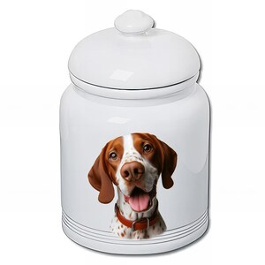May include: White ceramic dog treat jar with a lid. The jar features a detailed illustration of a brown and white dog with a red collar. The jar has a glossy finish and is suitable for storing pet treats.