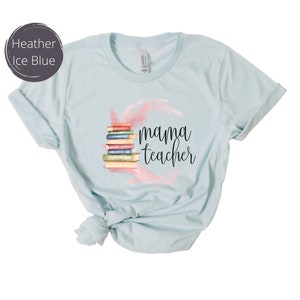 May include: Light blue t-shirt with a stack of books and pink feathers, and the text "mama teacher" printed on the front.