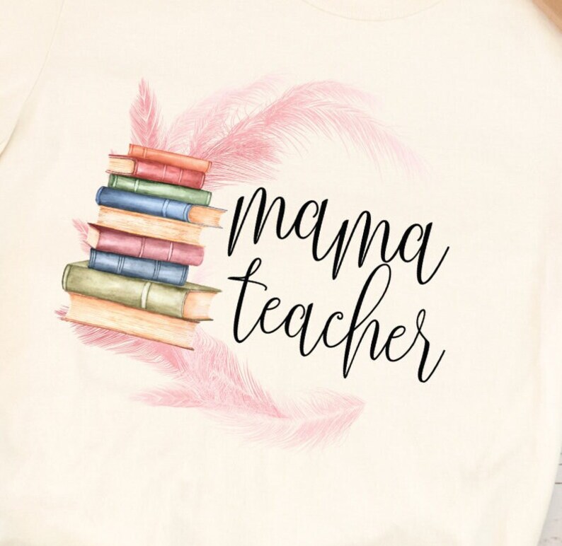 May include: A white t-shirt with a stack of books and pink feathers surrounding the text "mama teacher".