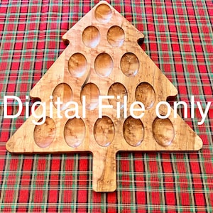 Peut inclure: Un plateau de service en bois en forme de sapin de Noël avec 15 indentations rondes. Le plateau est en bois brun clair avec un motif de grain de bois naturel. Le plateau est posé sur une nappe à carreaux rouge et verte.