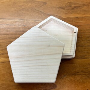 May include: A wooden box with a lid, both pieces are made of light wood and have a natural finish. The box is open and the lid is resting on top of the box.