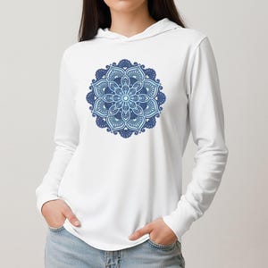 May include: White long-sleeve hoodie featuring a detailed blue mandala design on the front. The mandala has intricate patterns and gradients of blue. The hoodie has a drawstring hood and is made of a soft material.