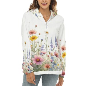 May include: White hoodie with a floral print featuring pink, yellow, and purple flowers. The hoodie has a zipper closure and a hood.