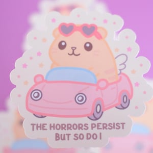 May include: A sticker depicting a cartoon hamster with heart-shaped sunglasses and wings, in a pink car. The text "THE HORRORS PERSIST BUT SO DO I" is below. The sticker has a white border with star and cloud accents.
