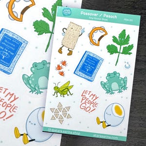 May include: Vinyl sticker sheets featuring Passover/Pesach themed illustrations. Designs include a matzah character, a blue book, a frog, and the text "Let My People Go!". The stickers are colorful and whimsical, perfect for decorating.