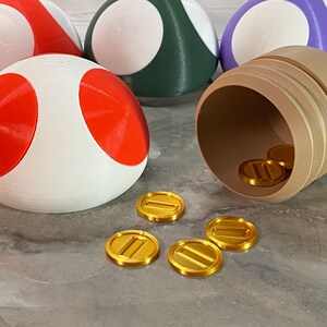 May include: A white and red mushroom-shaped object with gold coins spilling out of a brown barrel. The coins have a design of two parallel lines.