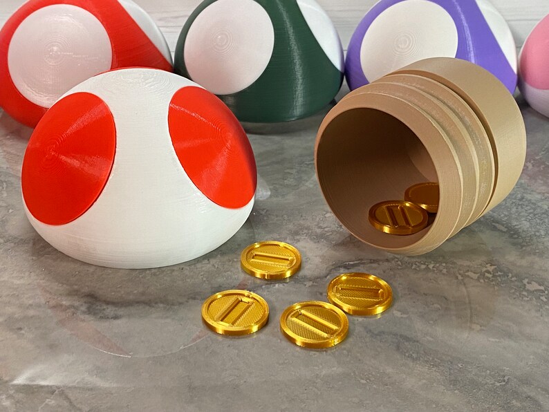 May include: A white and red mushroom-shaped object with gold coins spilling out of a brown barrel. The coins have a design of two parallel lines.