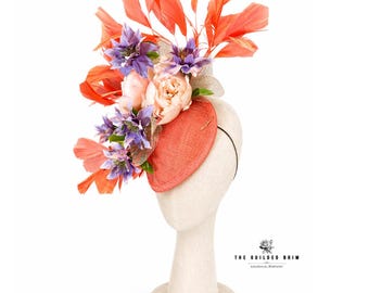 Tocado artesanal para el Derby de Kentucky con estampado floral en tonos coral y morado pálido.