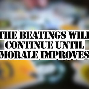 May include: Black and white sticker with the text "The beatings will continue until morale improves."