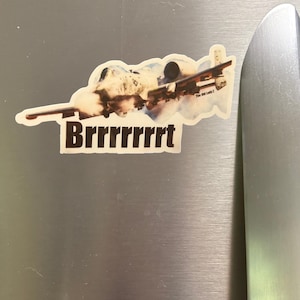 May include: A sticker featuring an A-10 Thunderbolt II aircraft in flight with a cloud of smoke and the text "Brrrrrrrt" printed in large black letters below the plane and "The Old Lady Z" printed in smaller text on the wing.