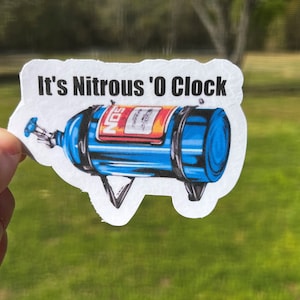 May include: A white sticker with the text "It's Nitrous 'O Clock" and a blue and red nitrous oxide bottle with the word "NOS" on it.